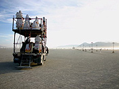 Lamplighters ride their double-decker flatbed, Lucifer, across the playa in the direction of the man.