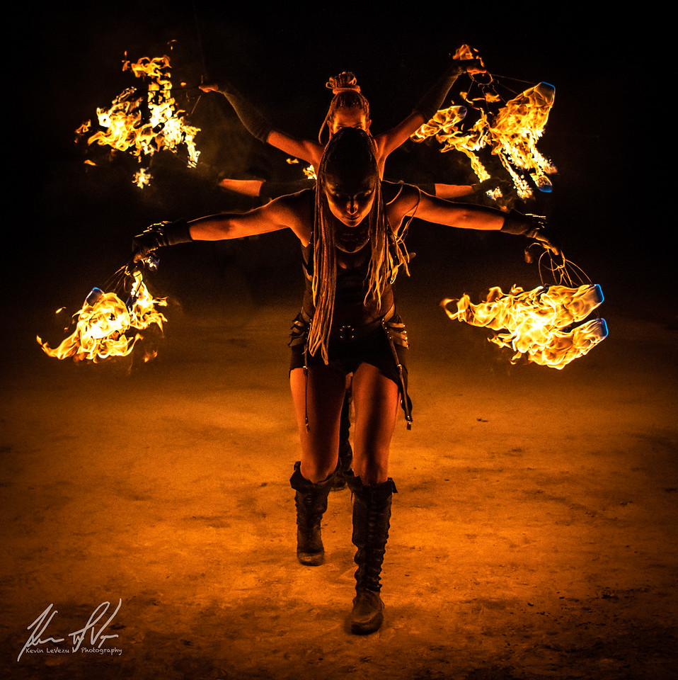 Fire dancers holding four flaming balls