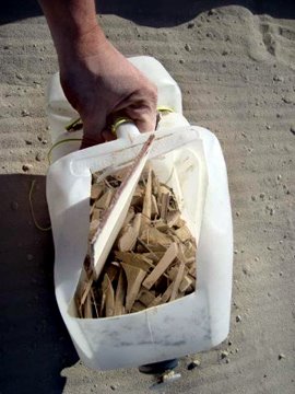 a MOOP bucket filled with shards of wood debris