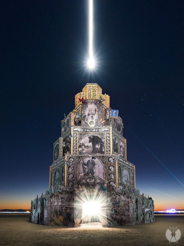 A tiered piece of art at Black Rock City with a bright light shining from the top. 