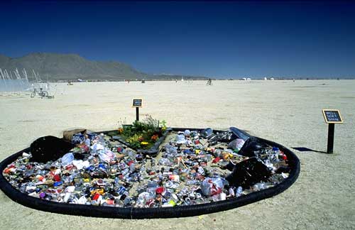 A pile of trash on the ground made into an art installation.