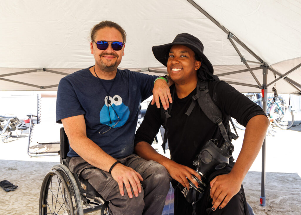 Two participants in Black Rock City smile at the camera. 