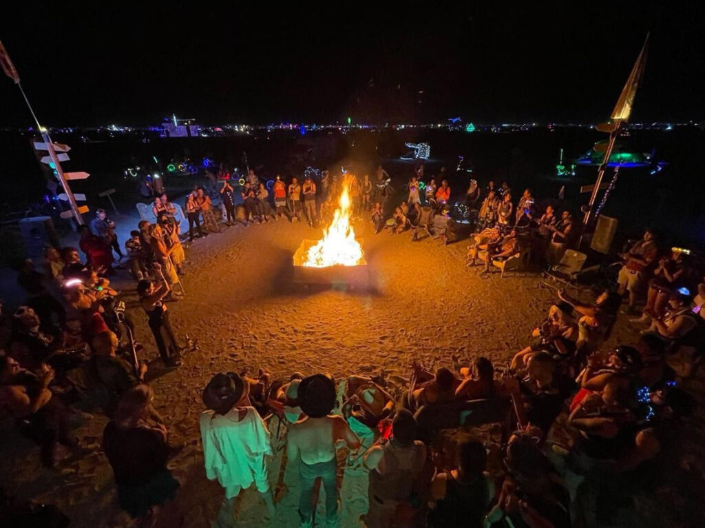 Group of burners sitting around a fire.