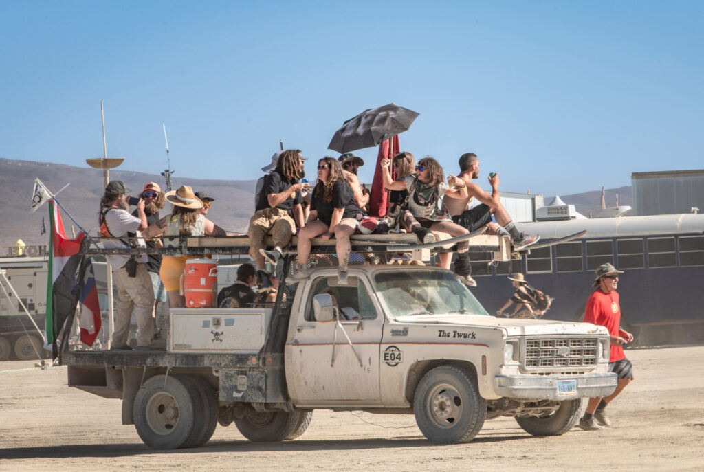 The Twurk truck in the DPW Parade with passengers in the bed and on the equipment rack.