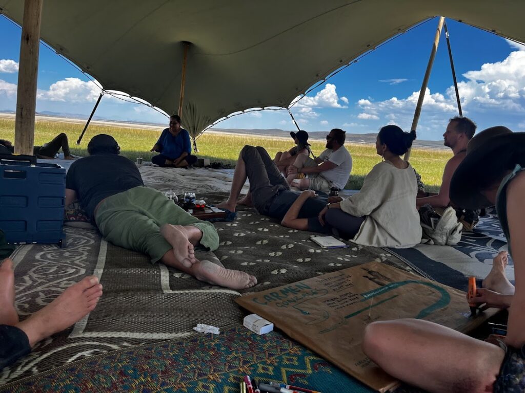 Group of people gathered around under a large tent