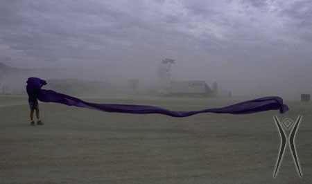 A long piece of fabric stretches across the frame, blown by the wind during a dust storm.