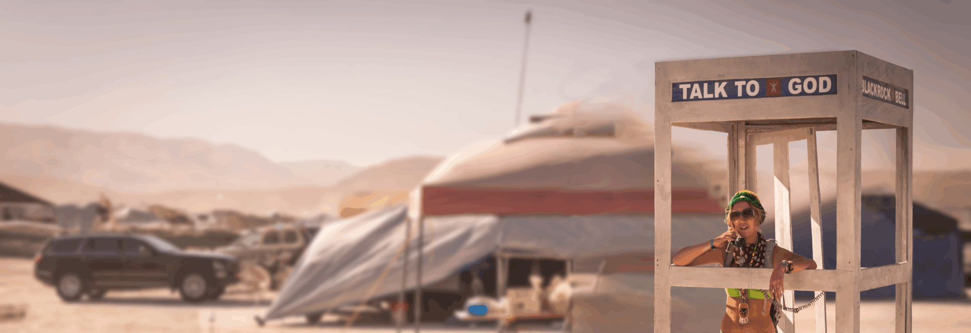 Person standing in Blackrock Bell phone booth labeled Talk to God