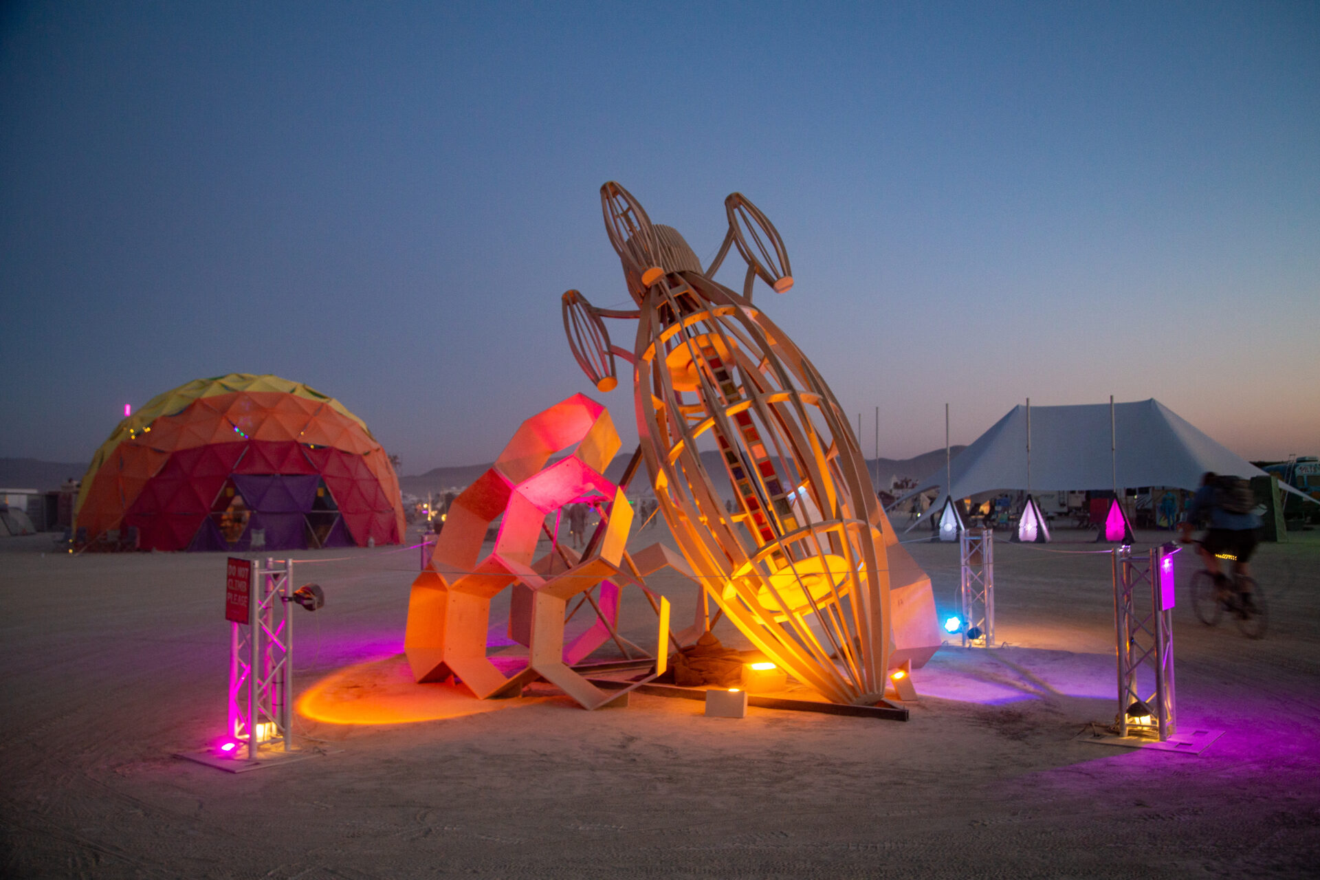 Brightly lit wireframe rocket nose touching the ground, next to an arc of hexagons.