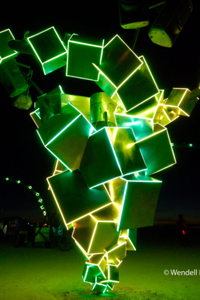 green and yellow lights trim cubes stacked on their corners in a tornado pattern