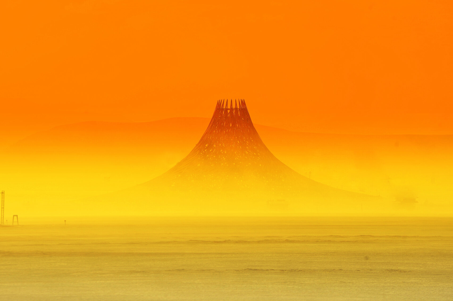 the top of the temple peeks above the dust at sunset