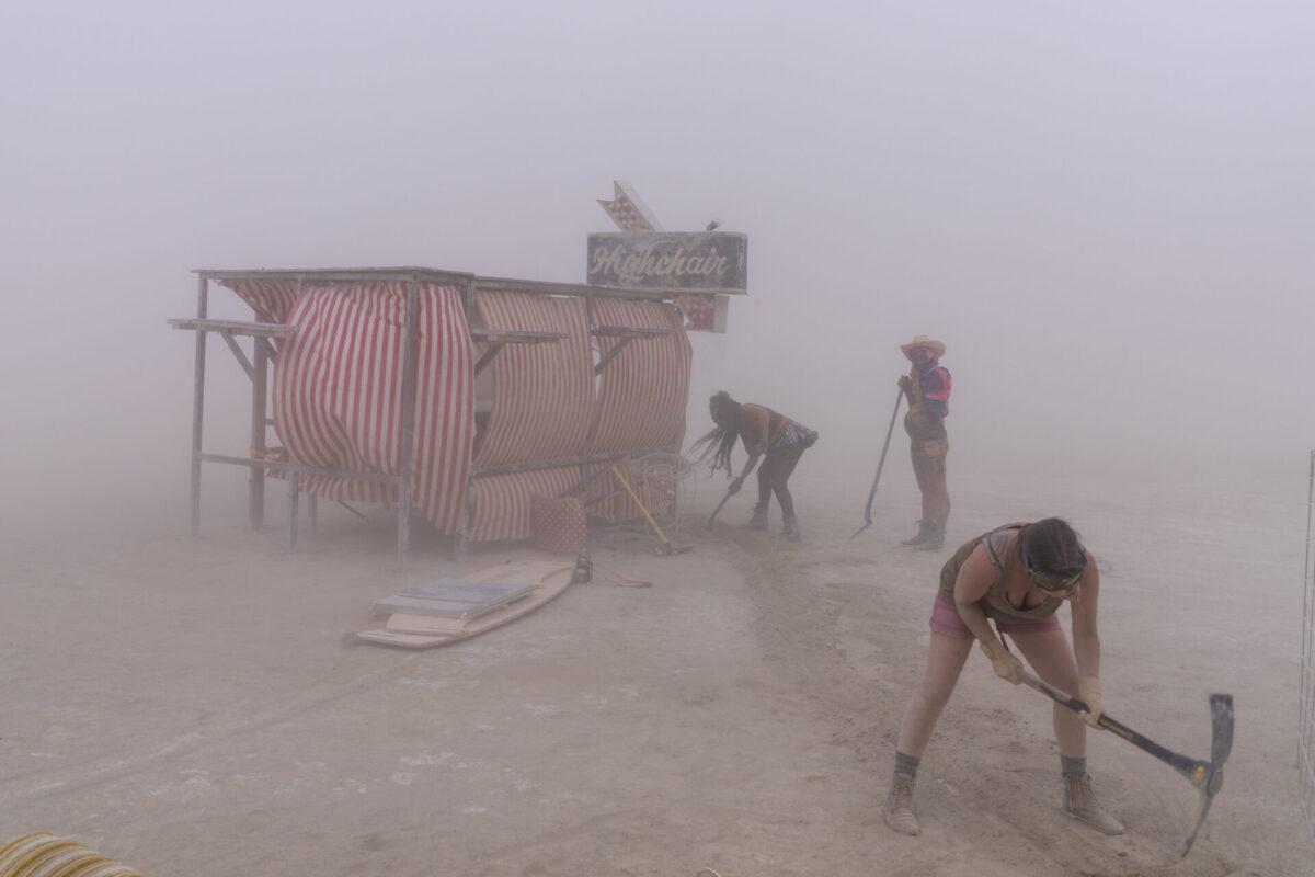 People trenching and stowing materials during a dust storm