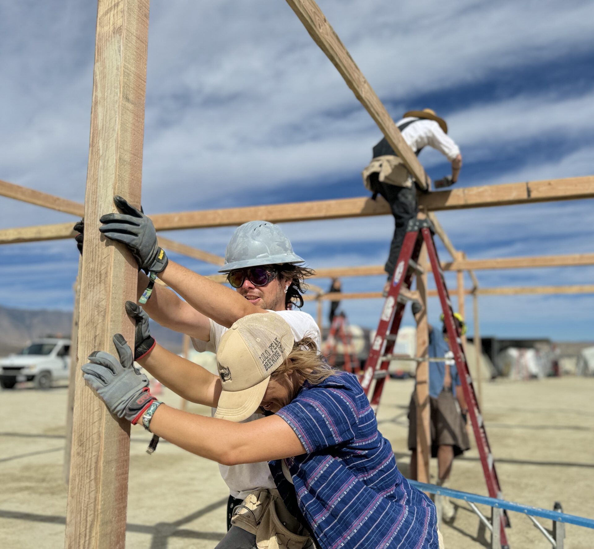 People installing a wooden post.