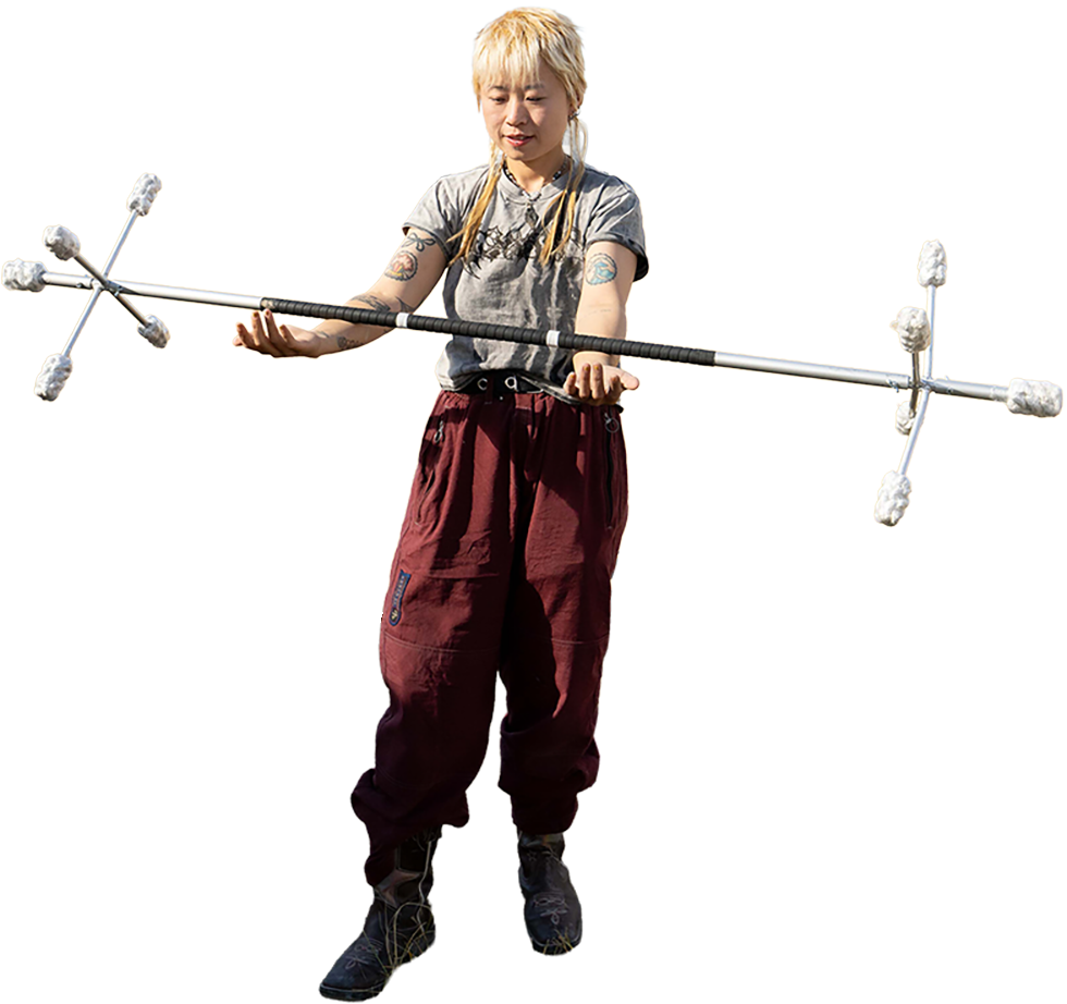 A person practicing to spin fire poi with a Dragon Staff.