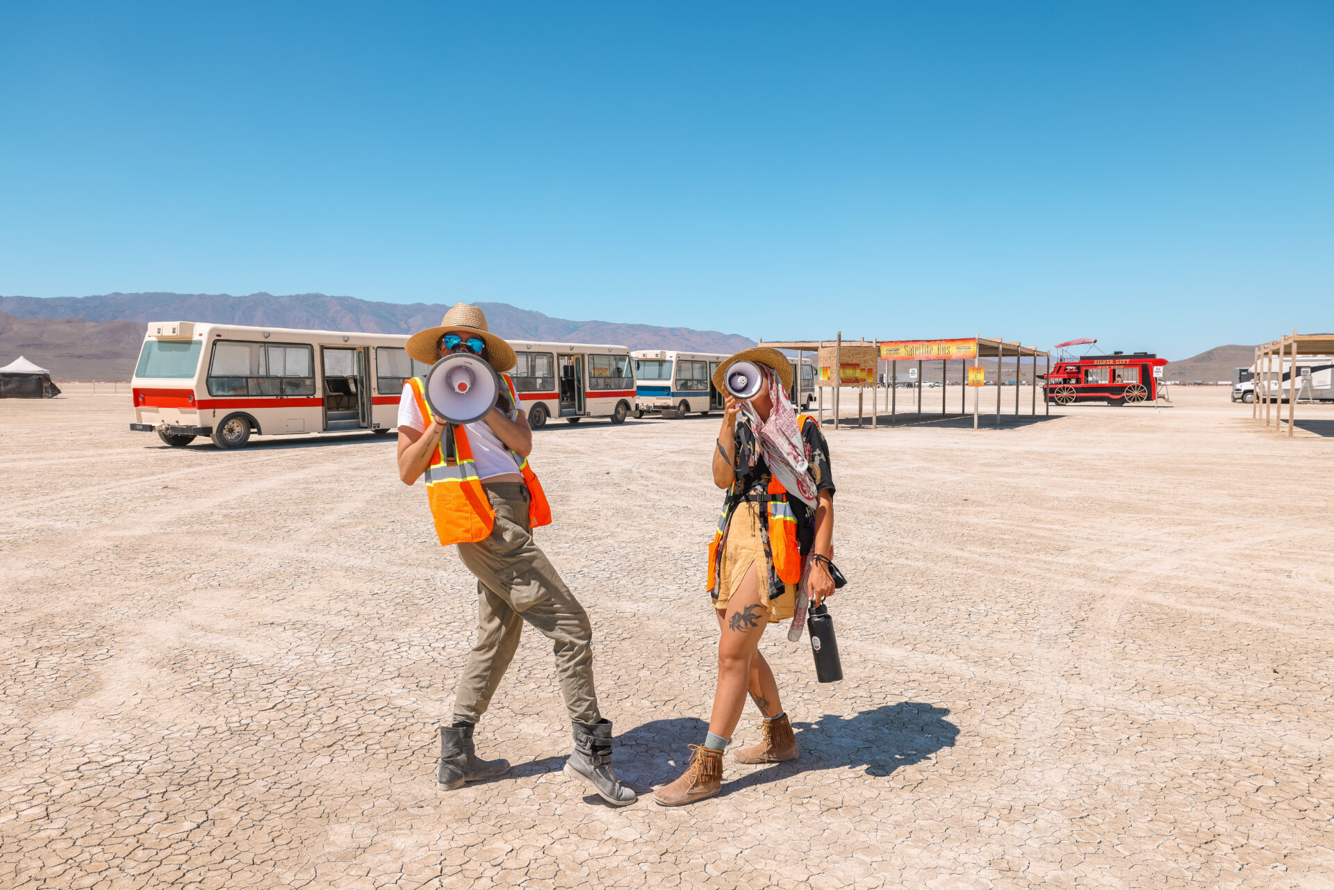 People in orange vests with megaphones at the Burner Express drop-off location.