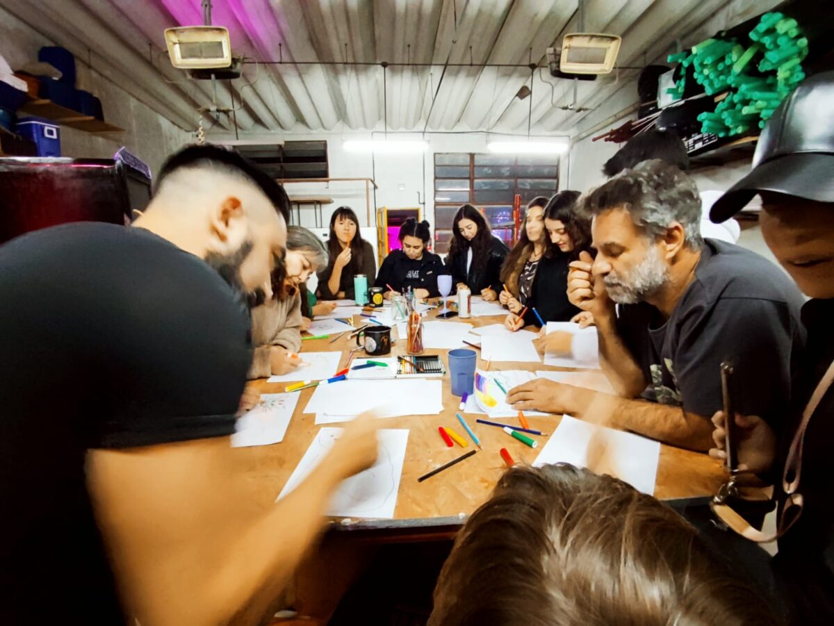Multigenerational group gathered around a table, sketching with markers and pencils.
